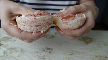 Kadın sulu bir portakal soyar.