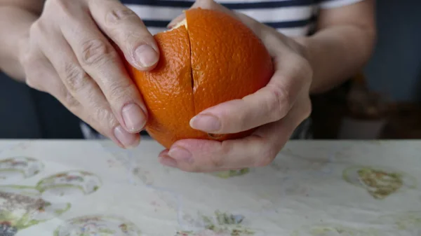 Woman Peels Juicy Orange — Stock Photo, Image