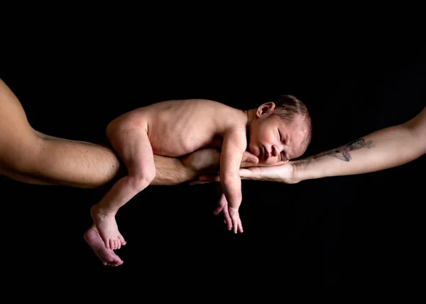 Um bebê recém-nascido dormindo pacificamente detido por seus pais. Conceito familiar — Fotografia de Stock