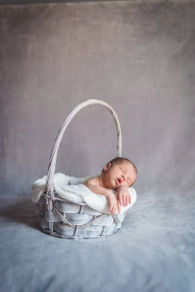 Une petite fille qui dort dans un panier pendant qu'elle dort. Concept de session nouveau-né — Photo