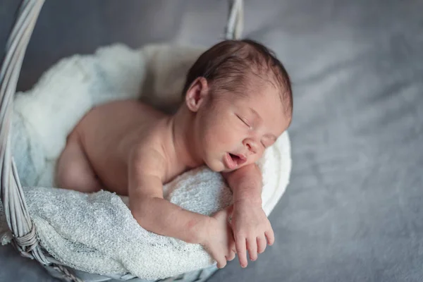 Ein neugeborenes Mädchen schläft in einem Korb, während sie schläft. Neugeborenes Sitzungskonzept — Stockfoto