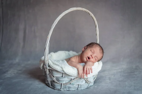 Une petite fille qui dort dans un panier pendant qu'elle dort. Concept de session nouveau-né — Photo