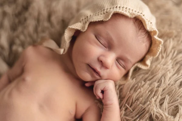 Ett nyfött barn sover fridfullt i en brun hatt. Begreppet nyfödd session — Stockfoto