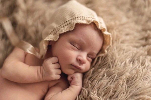 Ein neugeborenes Baby, das friedlich in einem braunen Hut schläft. Neugeborenes Sitzungskonzept — Stockfoto