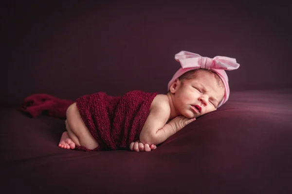 Ein neugeborenes Baby mit einem Stirnband. Neugeborenes Sitzungskonzept — Stockfoto