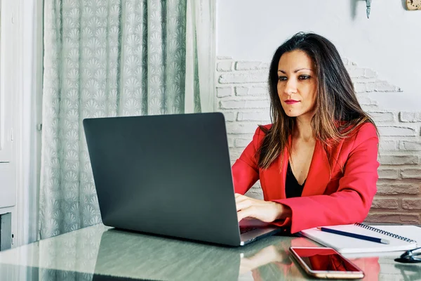 young executive woman working from home with her laptop