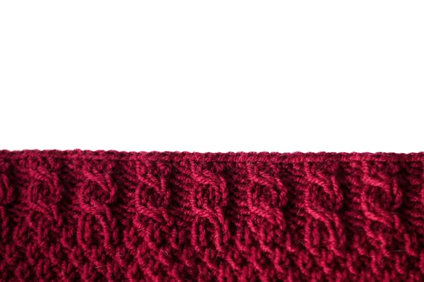 Red knitted plaid. The edge of the knitted fabric on a white bac — Stock Photo, Image