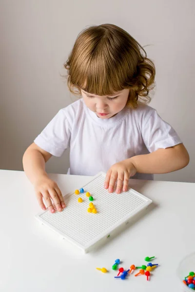 Fille bouclée jouer à la table dans une mosaïque colorée . — Photo