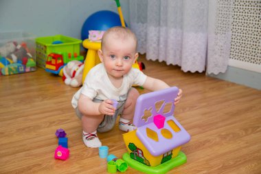 Çocuk çok renkli plastik bir oyunda yerde oynuyordu.