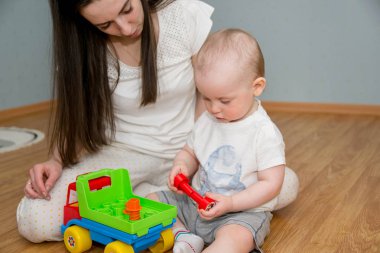 Küçük bir çocuk yerde bir daktiloyla oynuyor. Bu çocuk...
