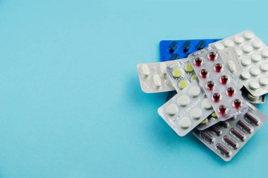 İlaçlar, haplar, vitaminler mavi arka plandaki bir pakette. Kopyalamak için boşluk.