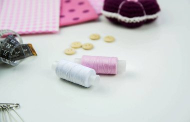 Beyaz arkaplana dikmek için pembe iplik makarası.