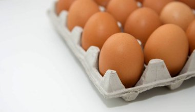 Tavuk yumurtaları beyaz bir masada paketleniyor. Boşluğu kopyala.