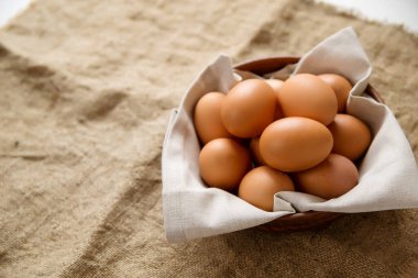 Çuval bezinden bir peçeteyle kilden tabakta tavuk yumurtası. Boşluğu kopyala.