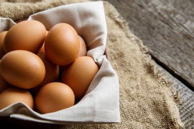 Çuval bezinden bir peçeteyle kilden tabakta tavuk yumurtası. Yukarıdan bak. Boşluğu kopyala.