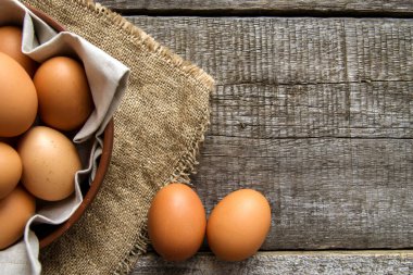 Kil tabakta, keten peçeteli tavuk yumurtaları ve çuval bezinde iki yumurta. Yukarıdan bak. Boşluğu kopyala.