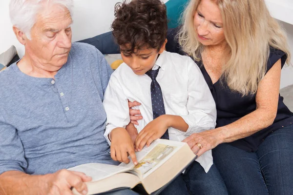 Älskar Morfar Och Mormor Med Sonson Läser Tillsammans Ordbok Soffan — Stockfoto