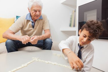 Büyükbaba ve torun Domino oynuyorlar.