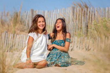 Karmaşık anlar, kumullarda güneşlenen rahat kadınlar, güzel doğanın, özgürlüğün ve huzurlu manzaranın tadını çıkarıyorlar. Tatil kavramı, özgürlük, arkadaşlık, mutluluk, neşe ve refah