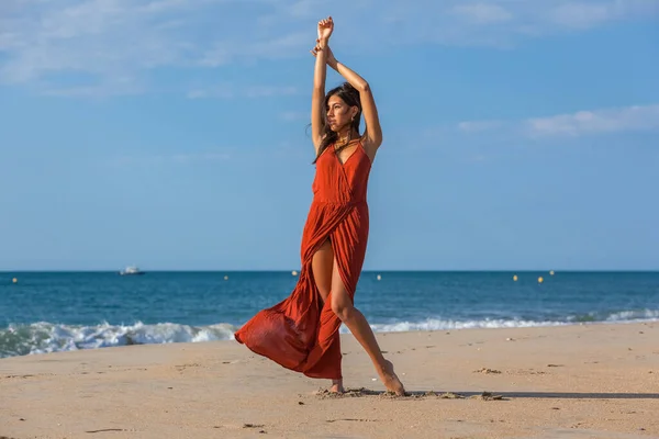 穿着红衣服赤脚站在沙滩上的年轻漂亮的女人 在海上享受自由的快乐女孩 — 图库照片