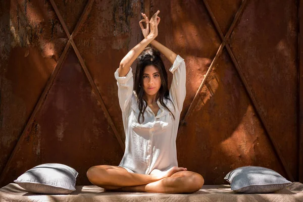 Bağdaş kurup bahçede yoga yapan genç bir kadın. İç huzuru bulmak. Pozitif enerji. Özgürlük için. Rahatlama. Meditasyon