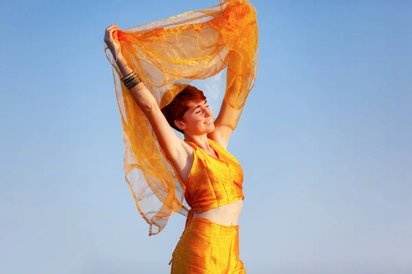 FREEDOM, MOVEMENTS, WOMAN ON A GATEWAY WITH A ORANGE SCARF