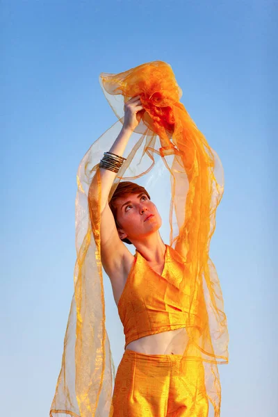 FREEDOM, MOVEMENTS, WOMAN ON A GATEWAY WITH A ORANGE SCARF