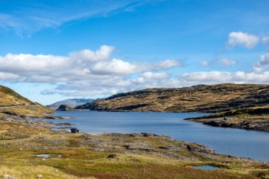 Norveç yüksek dağları güneşli bir günde göl. Vahşi doğa yolculuğu, mavi gökyüzü, parlak renkler. Yürüyüş İskandinav eğlence manzarası