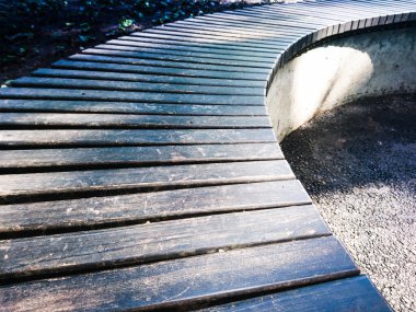 Ahşap bank mimarisi elementi kontrastı park arka planında karanlık kentsel detay dalgalanıyor