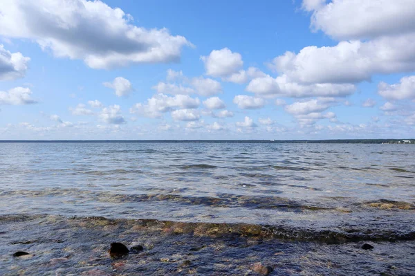 輝く水と青い空の風景の背景に素晴らしい雲を持つ国立公園内の大きな湖の美しいベラルーシの空 — ストック写真