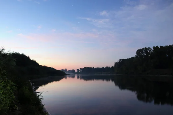 美丽而平静的日出 在河边的天空中 星星映照在镜面的水面上 树木轮廓 云彩和落日照片 — 图库照片