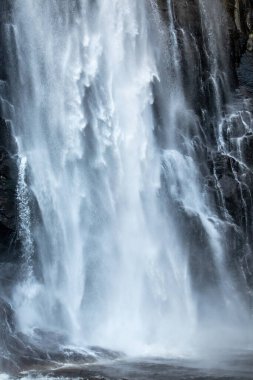 Skjervsfossen şelalesi düşen bulanık su dikey duvar kağıdı. Norveç Doğa Yolculuğu Güçlü beyaz, ipeksi akarsu