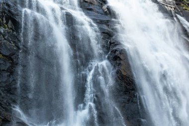Skjervefossen şelalesi bulanık suyu kapatıyor. Norveç Doğa Yolculuğu Güçlü beyaz, ipeksi akarsu