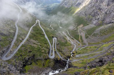 Ünlü Norveç dağları vadi manzaralı Trollstigen yolu. Kayalar, şelaleler, dramatik bulutlar, turizm, Avrupa seyahati