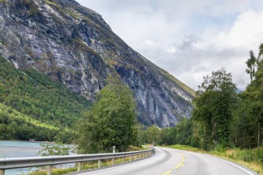 Norveç 'te Endülüs yakınlarında dağlar, kayalık tepeler ve nehir manzaralı doğa vadisi bulutlu. Arabayla seyahat, doğa turizmini sürdürmek..