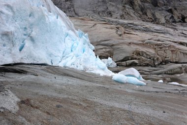 Nigardsbreen buzulu ve kar Jostedalsbreen Ulusal Parkı 'na yakın. Norveç dağlarının manzarası koyu mavi buz, kayalar ve karla kaplı. İklim değişikliği, eriyen buzullar