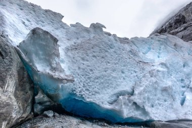 Nigardsbreen buzulu ve kar Jostedalsbreen Ulusal Parkı 'na yakın. Norveç dağlarının manzarası koyu mavi buz, kayalar ve karla kaplı. İklim değişikliği, eriyen buzullar