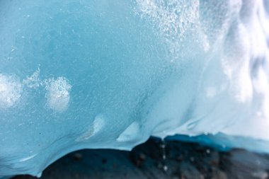 Buzul, Jostedalsbreen Ulusal Parkı 'nda buzdan geçen parlak mavi bir ışık. Norveç dağları koyu mavi buz mağarası, kayalar, kar. İklim değişikliği, su damlaları, eriyen buzullar.