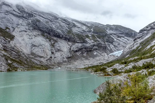 挪威高山景观 靠近湖面 碧蓝的海水 前往Jostedalsbreen国家公园的Nigardsbreen的阴天跟踪旅行 — 图库照片