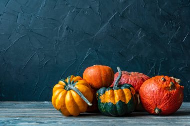 ahşap masa ile koyu arka plan üzerinde renkli kabaklar