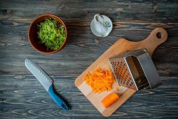 Зеленая редиска, морковь, соль и нож на деревянном столе. Ингредиенты для приготовления традиционного русского блюда. Национальная кухня — стоковое фото