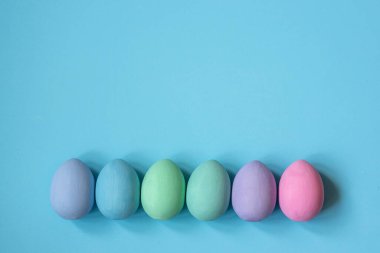 Mavi arka planda çok renkli yatak renginde yumurtalar.