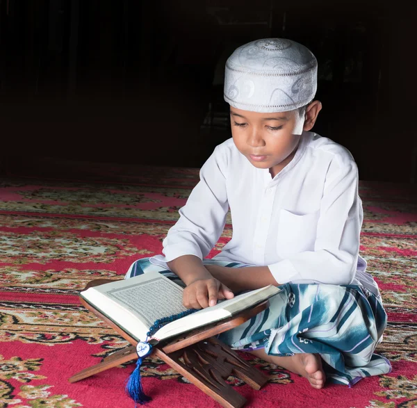 Niño musulmán asiático con cara de sonrisa lee el Sagrado Corán — Foto de Stock