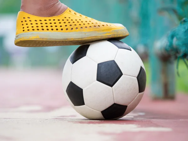 futsal player foot and ball on playground