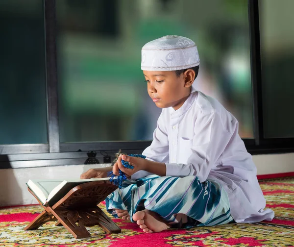 Asiatisches muslimisches Kind mit lächelndem Gesicht liest den heiligen Qran — Stockfoto