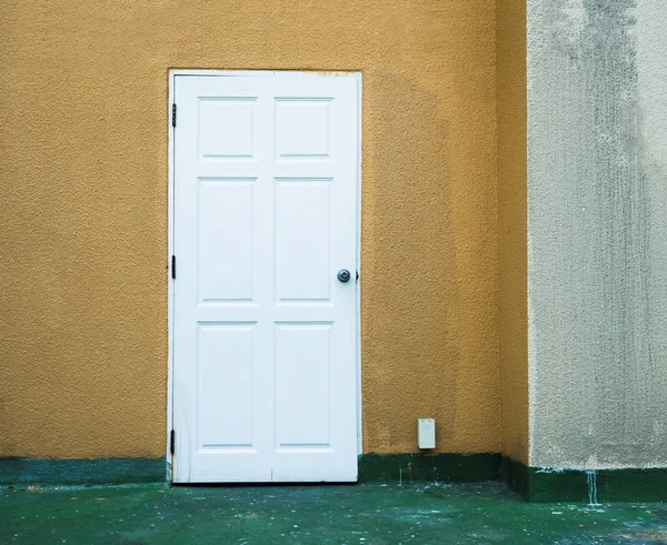 Witte exit deur op de gele muur — Stockfoto