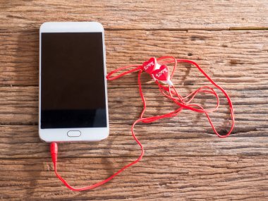 akıllı telefon ve kulakları ahşap arka plan üzerinde fiş