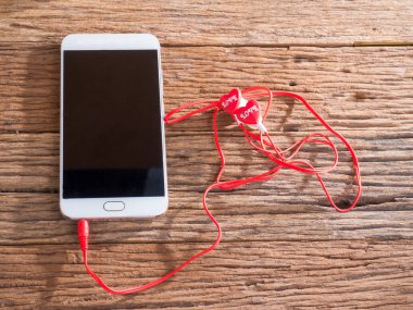 akıllı telefon ve kulakları ahşap arka plan üzerinde fiş