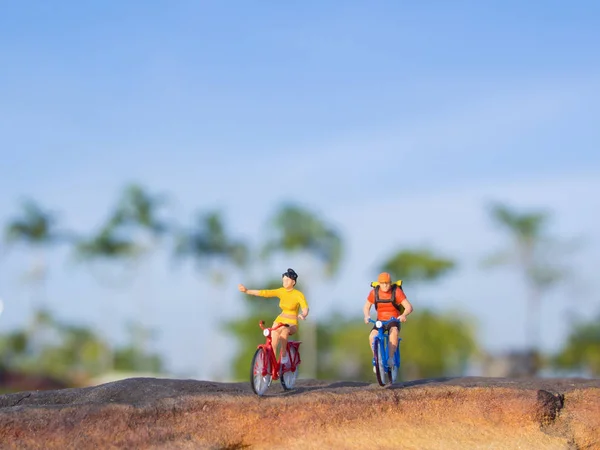 Mini figure toys ride bicycle outdoor on the sunny day — Stock Photo, Image