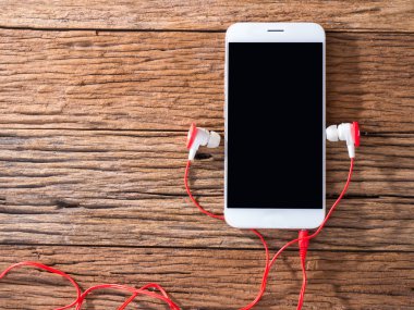 akıllı telefon ve kulakları ahşap arka plan üzerinde fiş